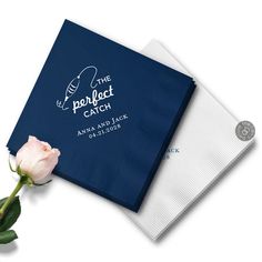 a white rose sitting on top of a napkin next to a blue and white napkin