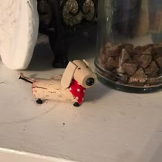 a dog figurine sitting on top of a counter next to some chocolates