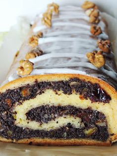 a chocolate cake roll with white frosting and walnuts