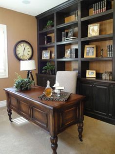 an office with a desk, bookshelf and clock