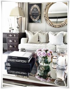 a living room filled with lots of furniture and flowers on top of a coffee table