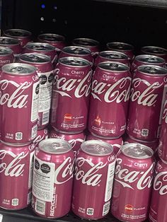 many cans of coca - cola are stacked on top of each other