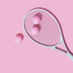 a pink tennis racquet with three balls on it and the racket is upside down