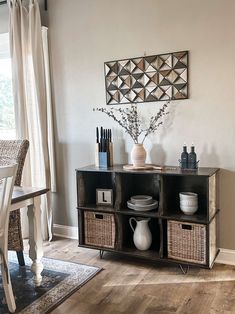 a table with some vases on top of it next to a chair and window