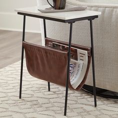 With its mixed media design the Etanbury accent table with magazine holder is whats newand whats you. Fusion of black metal white marble and brown faux leather creates a contemporary aesthetic thats the genuine article. What's IncludedAccent Table | Signature Design by Ashley Etanbury Accent Table in Brown/Black/White | Nebraska Furniture Mart Ashley Table, Marble Top Accent Table, White Accent Table, Marble Top End Tables, Black Accent Table, Tall End Tables, Mixed Media Design, Magazine Holder, Ornate Furniture