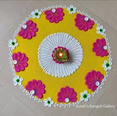 a yellow and pink table cloth with flowers on it, surrounded by white doily