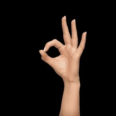 a person's hand making the v sign with their fingers against a white background