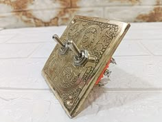 a small metal object sitting on top of a white tile floor