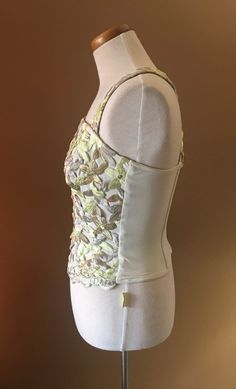 "Beautiful and unusual camisole accented with metallic floral appliqués. The top is made of nylon and Lycra for a slimming effect. Staves are added for a mild support and to maintain a slimming look. Top can be worn with jeans as well as slacks or skirt. Measures 16\" from armpit to armpit 10.5\" from armpit to hem 13\" across the waist This top has a lot of stretch!" Party Fitted Camisole With Tank Straps, Fitted Gold Camisole For Night Out, Fitted Tank Top For Party, Party Top With Boned Bodice And Tank Straps, Spring Evening Tank Top With Built-in Bra, Party Tank Top With Spaghetti Straps And Boned Bodice, Party Tank Top With Boned Bodice And Spaghetti Straps, Summer Boned Bodice Tank Top For Night Out, Summer Tank Top With Boned Bodice For Night Out