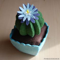 a small potted plant with a blue flower in it