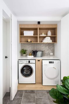 a washer and dryer in a small laundry room with open shelving on the wall