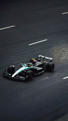 a man driving a racing car on top of a race track