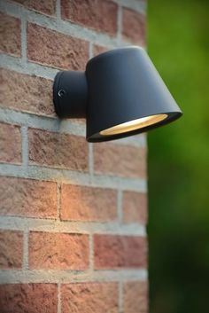 a black lamp mounted on the side of a brick wall