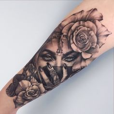 a woman's arm with roses and a face tattoo on the left side of her body