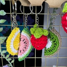 crocheted fruit keychains hanging from a wire rack