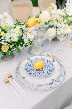 an elegant table setting with white and yellow flowers