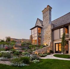 a large house that is surrounded by grass and flowers