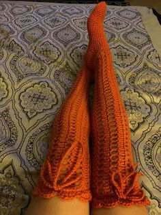 the legs of a woman wearing orange knitted socks