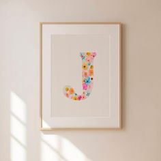 the letter j is made up of colorful flowers and butterflies on it's white frame