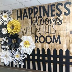 a bulletin board with flowers on it and the words happiness is blooming within this room