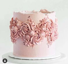 a pink frosted cake with flowers on it