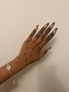 a woman's hand with hendix on it and her nails painted brown