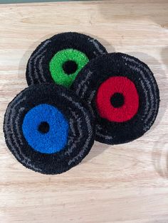 three black, red and green circles on a wooden surface