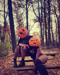 two people are sitting on a bench with pumpkins in their heads and one is wearing fishnet stockings