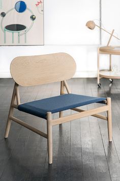 a wooden chair sitting on top of a hard wood floor next to a blue seat cushion