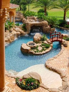 an outdoor pool with a bridge and water features