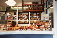 a bakery filled with lots of different types of breads and pastries on display