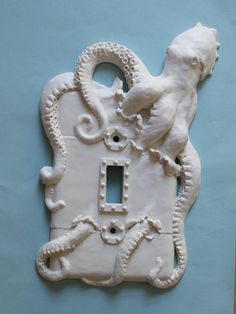 a white light switch cover with an octopus and seahorse on it's side