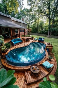 an above ground pool surrounded by wooden decking and blue furniture in the middle of a yard