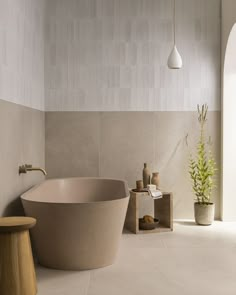 a bath tub sitting next to a wooden stool in a white tiled bathroom with potted plants