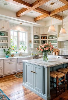 a large kitchen with white cabinets and wooden beams on the ceiling is decorated with pink flowers