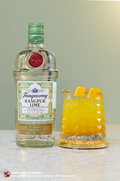 a bottle of gin and a glass filled with orange juice