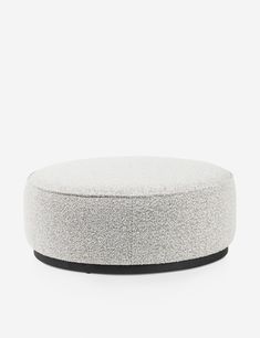 a round ottoman sitting on top of a white floor