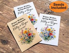 three seed packets with flowers on them sitting on top of a wooden table next to each other