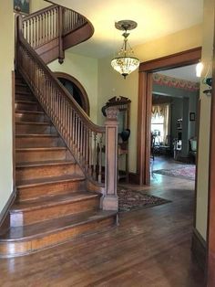 a staircase leading to the second floor of a house with wood floors and wooden handrails