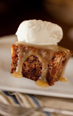 a piece of cake on a plate with ice cream and caramel drizzle