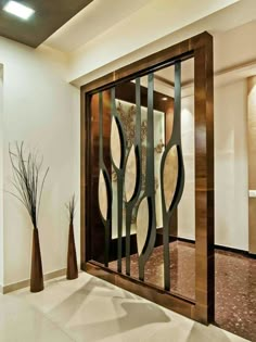 an open glass door in the middle of a room with vases on the floor