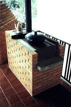 a stove sitting on top of a brick wall next to a window