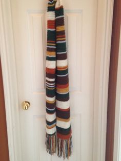 a multicolored scarf hanging on the front door to hang it from a hook