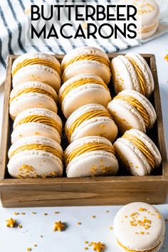 a wooden box filled with white and yellow macarons on top of a table