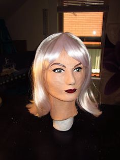 a mannequin head with blonde hair and red lipstick