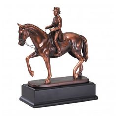 a bronze statue of a man riding a horse on a black base with a white background