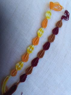 an orange, yellow and brown crochet necklace on a mannequin's torso