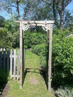 an old wooden arbor in the middle of a garden