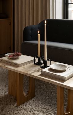 a coffee table with two candles and books on it