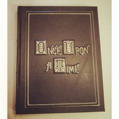 a book with the words once upon a time written in metal letters on it's cover